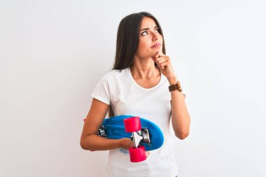 İzole edilmiş beyaz arka planda duran genç ve güzel bir kadın. Ciddi bir yüz ifadesi. Soru sormayı düşünüyor.