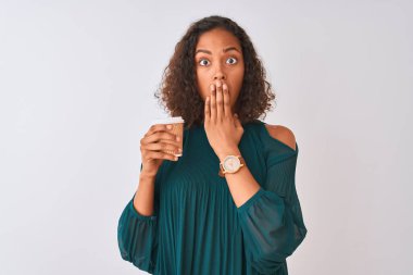 Genç Brezilyalı kadın kahve içerek uzaklaşıyor. İzole edilmiş gri arka planda duruyor. Ağzı kapalı.