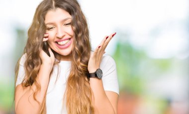 Kocaman bir gülümseme ile çığlık zaferini kutluyor ve ellerini kaldırdı telefon çok mutlu ve heyecanlı, kazanan ifade üzerinde alarak genç yetişkin kadın