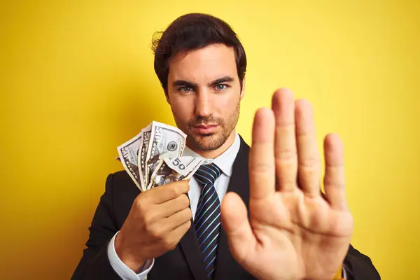 Young Handsome Businessman Wearing Suit Holding Dollars Isolated Yellow Background — Stock Photo, Image