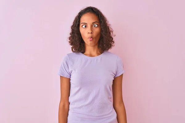 年轻的巴西女人穿着T恤 站在孤立的粉色背景上 用嘴唇 疯狂和滑稽的姿势做鱼脸 有趣的表达方式 — 图库照片