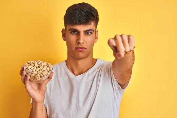 Giovane Indiano Possesso Ciotola Con Pistacchi Sfondo Giallo Isolato Puntando — Foto Stock