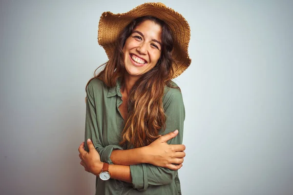 年轻美丽的女人在度假时穿着绿色的衬衫 头戴一顶白色的独立背景的帽子 高兴的脸上带着交叉的胳膊微笑着看着相机 积极的人 — 图库照片