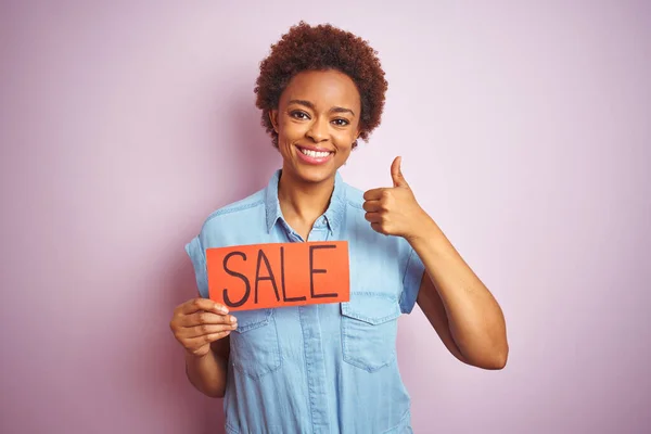 アフリカ系アメリカ人女性を保持販売ボード上ピンク隔離された背景幸せなで大きな笑顔を行いますOkサイン 親指アップで指 優れたサイン — ストック写真