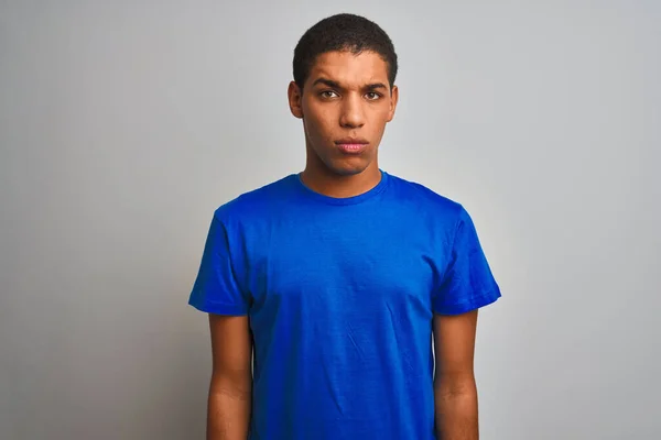 年轻英俊的阿拉伯男子穿着蓝色T恤 站在孤立的白色背景下 怀疑和紧张 因为问题皱着眉头 消极的人 — 图库照片