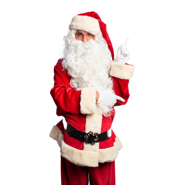 中年英俊男子 身穿圣诞老人服装 蓄着胡子 脸上挂着大大的笑容 手指头指向旁边看相机 — 图库照片