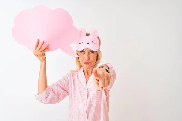 Middle age woman wearing sleep mask holding speech bubble over isolated white background pointing with finger to the camera and to you, hand sign, positive and confident gesture from the front