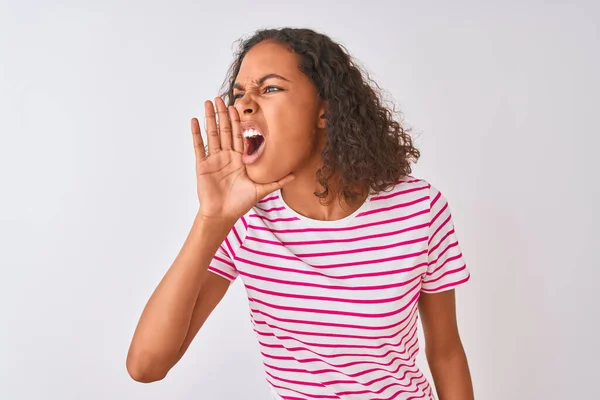 年轻的巴西女人穿着粉色条纹T恤 站在孤立的白色背景上大声喊着 一边手拉手一边喊着 传播概念 — 图库照片