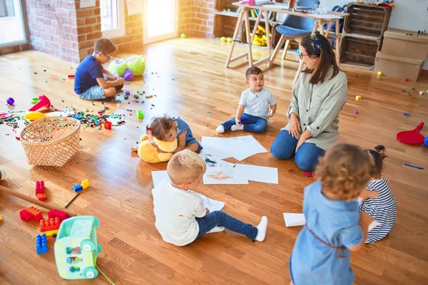 Vacker Lärare Och Grupp Småbarn Sitter Golvet Ritning Med Papper — Stockfoto