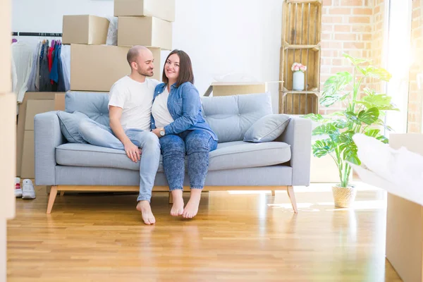 Pareja Joven Enamorada Relajándose Abrazándose Sentada Sofá Casa Nueva Sonriendo — Foto de Stock