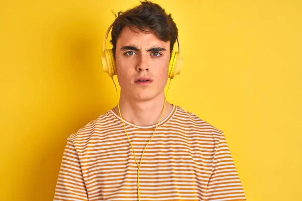 Εφηβικό Αγόρι Που Φοράει Ακουστικά Πάνω Από Απομονωμένο Κίτρινο Φόντο — Φωτογραφία Αρχείου