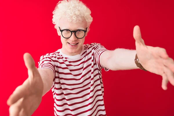 Mladý Blonďatý Albín Pruhovaném Tričku Brýlích Izolovaném Červeném Pozadí Dívá — Stock fotografie