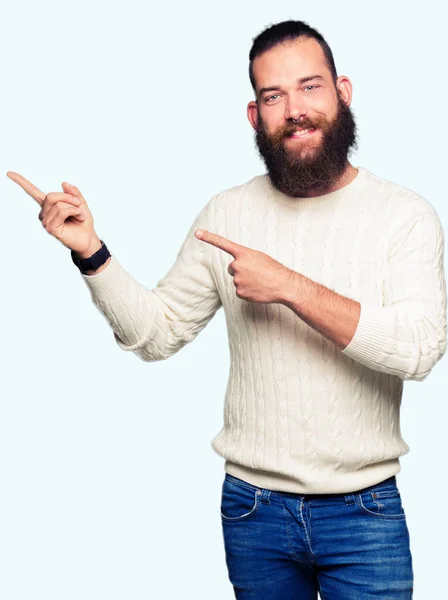 流行に敏感な若い男着て冬セーター笑顔で側に つの手と指で指しているカメラ目線 — ストック写真