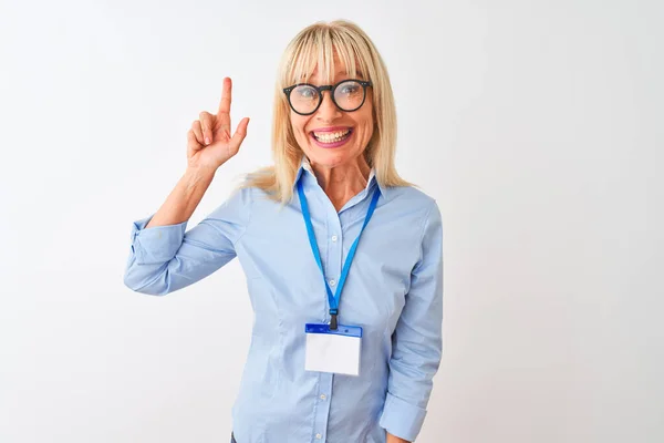 Middle age businesswoman wearing glasses and id card over isolated white background pointing finger up with successful idea. Exited and happy. Number one.