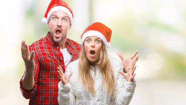 恋のクリスマス帽子をかぶっている若いカップル狂気を祝う背景を分離した腕を上げると成功のためびっくりし 叫んで興奮して目を開きます 勝者の概念 — ストック写真