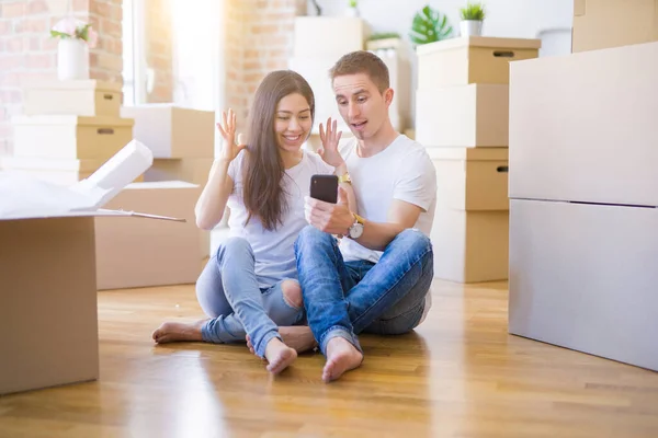 Hermosa Pareja Sentada Suelo Usando Teléfono Inteligente Nuevo Hogar Alrededor — Foto de Stock