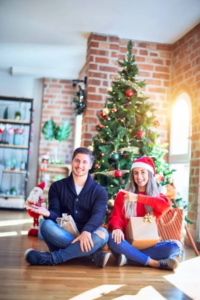 Junges Paar Mit Weihnachtsmannmütze Das Hause Boden Den Weihnachtsbaum Sitzt — Stockfoto