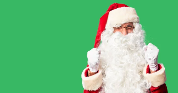中年英俊男子 身穿圣诞老人服装 蓄着胡子 站在那里兴奋地期待着成功 举起双臂 闭上双眼 微笑着庆祝胜利 赢的概念 — 图库照片