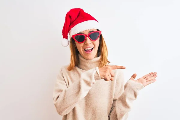 Красивая Рыжая Женщина Рождественской Шляпе Красных Солнцезащитных Очках Счастлива Указывая — стоковое фото