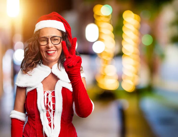中年妇女身穿圣诞老人服装 手指手画脚 面带微笑 自信而快乐 — 图库照片