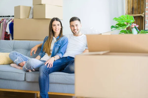 Pareja joven en el amor relajante sentado en el sofá en el nuevo hogar, s — Foto de Stock