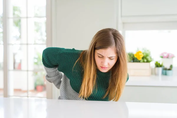 年轻而又漂亮的女人 穿着宽松的条纹毛衣 用手触摸 肌肉疼痛 — 图库照片