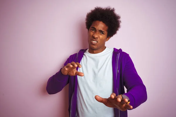 孤立したピンクの背景に立って紫色のスウェットシャツを着ている若いアフリカ系アメリカ人の男性は 嫌悪反応のために嫌悪感の表情 不満で恐ろしい嫌悪感の顔をしている 手を上げてどんなコンセプトでも — ストック写真