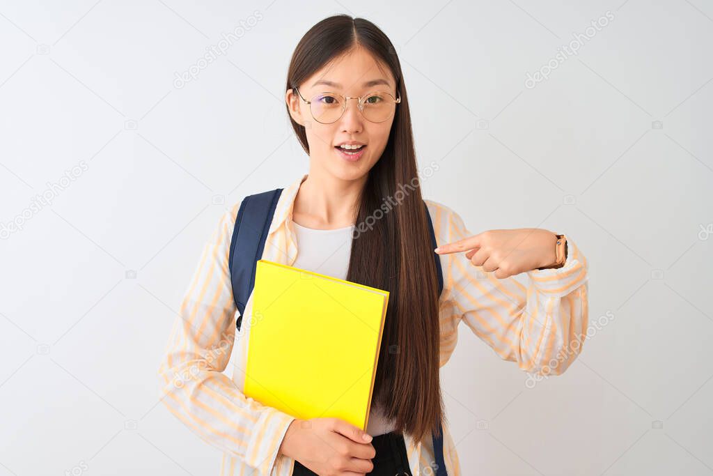 Chinese student woman wearing glasses backpack book over isolated white background with surprise face pointing finger to himself