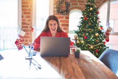 Güzel bir kadın evinde dizüstü bilgisayarla oturmuş Noel ağacının etrafında gülüyor ve kahkahalar atıyordu çünkü elleri vücutta komik bir şakaydı..