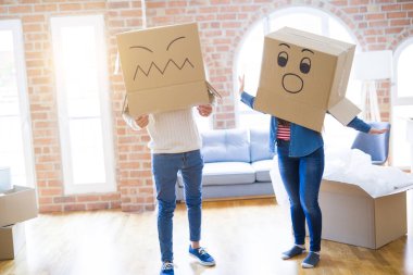 Çılgın çift kafa üzerinde komik yüzler ile kutuları giyiyor, yeni bir eve taşımak için mutlu eğlenceli