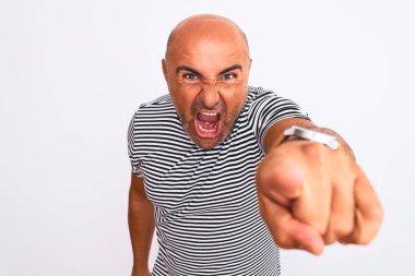 İzole edilmiş beyaz arka plan üzerine çizgili donanma tişörtü giyen yakışıklı bir adam kameraya kızgın ve sinirli olduğunu gösteriyor.