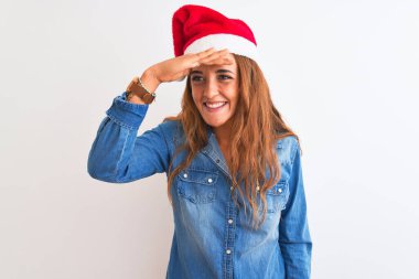 Genç, güzel, kızıl saçlı, izole edilmiş arka planda Noel şapkası takan çok mutlu ve tebessüm eden bir kadın. Konsept aranıyor.