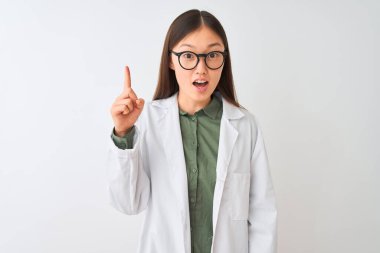 İzole edilmiş beyaz arka plan üzerine ceket ve gözlük takan genç Çinli bilim kadını başarılı bir fikir işaret ediyor. Heyecanlı ve mutlu. Bir numara..