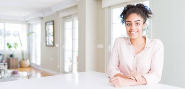 Afro saçlı, yüzünde mutlu ve serin bir gülümseme olan güzel Afro-Amerikan kadını geniş açılı. Şanslı kişi..