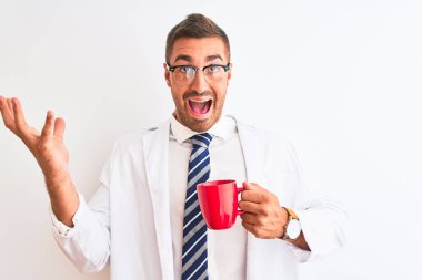 Genç yakışıklı terapist arka planda kahve içiyor çok mutlu ve heyecanlı, kazanan yüz ifadesi zaferi büyük bir gülümsemeyle kutluyor ve ellerini kaldırıyor.