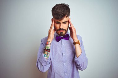 Mor gömlekli ve papyonlu genç bir adam izole edilmiş beyaz arka planda, baş üstünde baş ağrısı var çünkü stres var. Migren ağrısı..