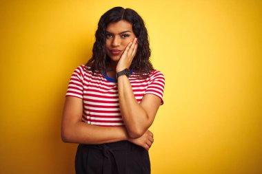 Transseksüel transseksüel kadın, sarı arka plan üzerinde ince tişört giyip kollarını kavuşturarak depresyondan sıkılmış ve yorgun göründüğünü düşünüyor..