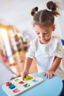 Anaokulunda matematik oyunu oynayan genç ve güzel bir çocuk.