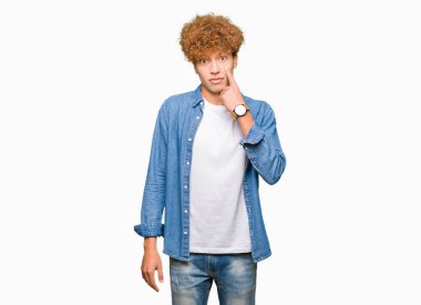 Afro saçlı kot giyen genç yakışıklı adam ceket işaret jest göz izlemek için şüpheli ifade