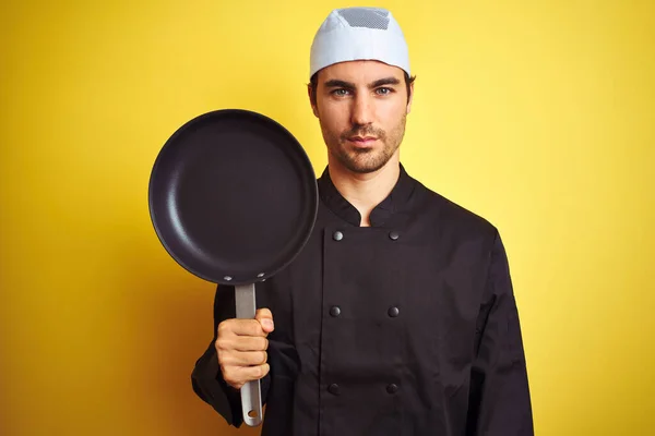 Jonge Chef Kok Uniform Hoed Met Kookpan Geïsoleerde Gele Achtergrond — Stockfoto