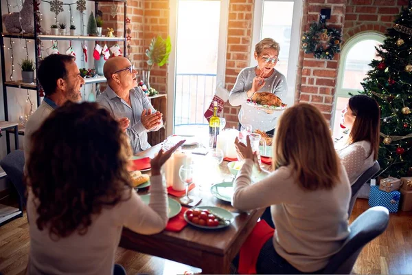 친구들 장식으로 크리스마스 이브를 축하하며 집에서 식사를 스러운 요리를 보여준다 — 스톡 사진