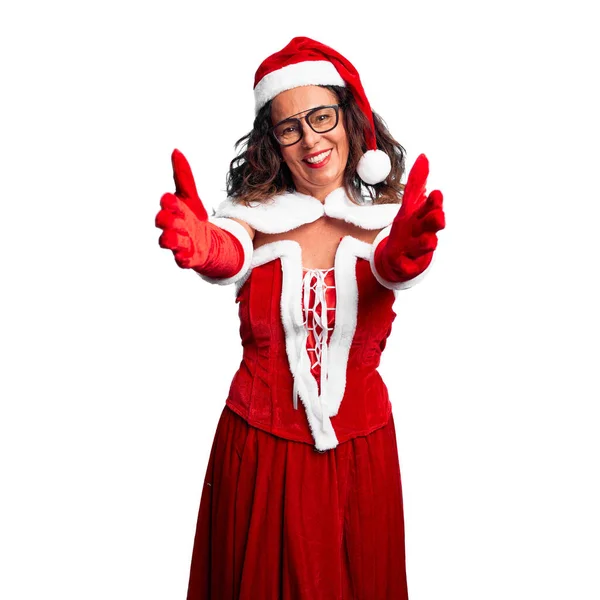 中年妇女穿着圣诞老人的服装 看着镜头 张开双臂拥抱 喜庆的表情拥抱幸福 — 图库照片