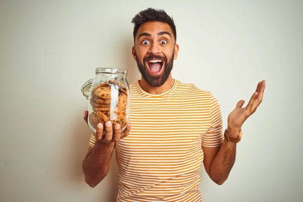 Jonge Indiaanse Man Houdt Pot Koekjes Staande Geïsoleerde Witte Achtergrond — Stockfoto