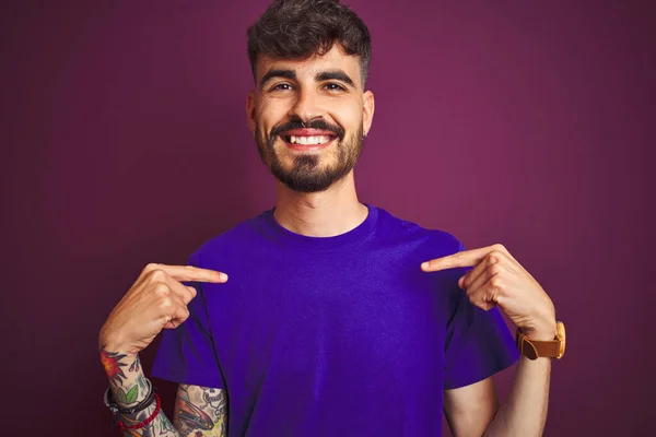 Jovem Com Tatuagem Vestindo Camiseta Sobre Fundo Roxo Isolado Olhando — Fotografia de Stock