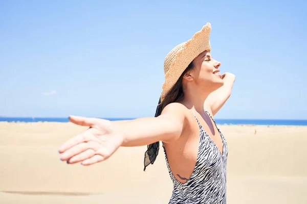 若いです美しいです女性日光浴とともにオープン腕身に着けています夏の水着でMaspalomas砂丘Bech — ストック写真