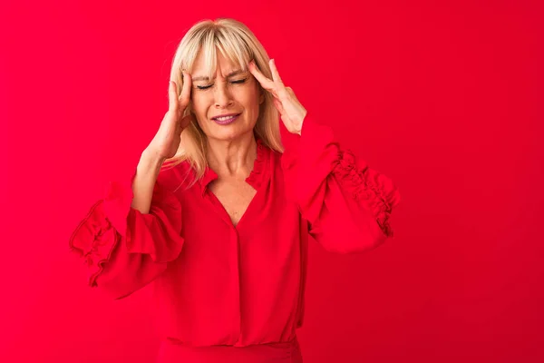 Middle age woman wearing elegant shirt standing over isolated red background with hand on head for pain in head because stress. Suffering migraine.