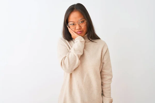 年轻的中国女人穿着高领毛衣 戴着眼镜 站在孤立的白色背景上 看起来疲惫不堪 对交叉双臂的抑郁症感到厌烦 — 图库照片