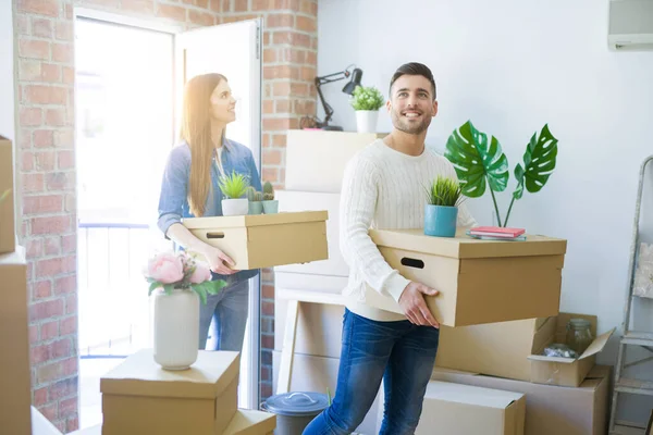 Jeune couple déménageant dans une nouvelle maison, souriant heureux tenant cardboa — Photo