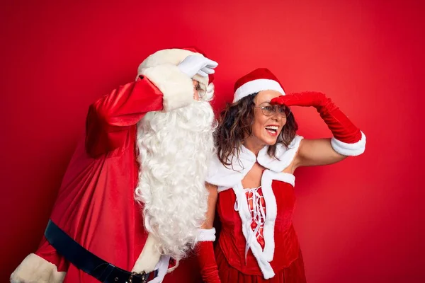Medelålders Par Bär Santa Kostym Och Glasögon Över Isolerad Röd — Stockfoto