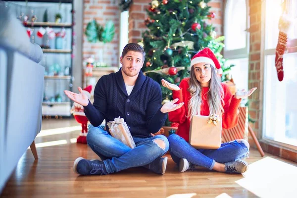 Casal Jovem Vestindo Chapéu Papai Noel Sentado Chão Torno Árvore — Fotografia de Stock